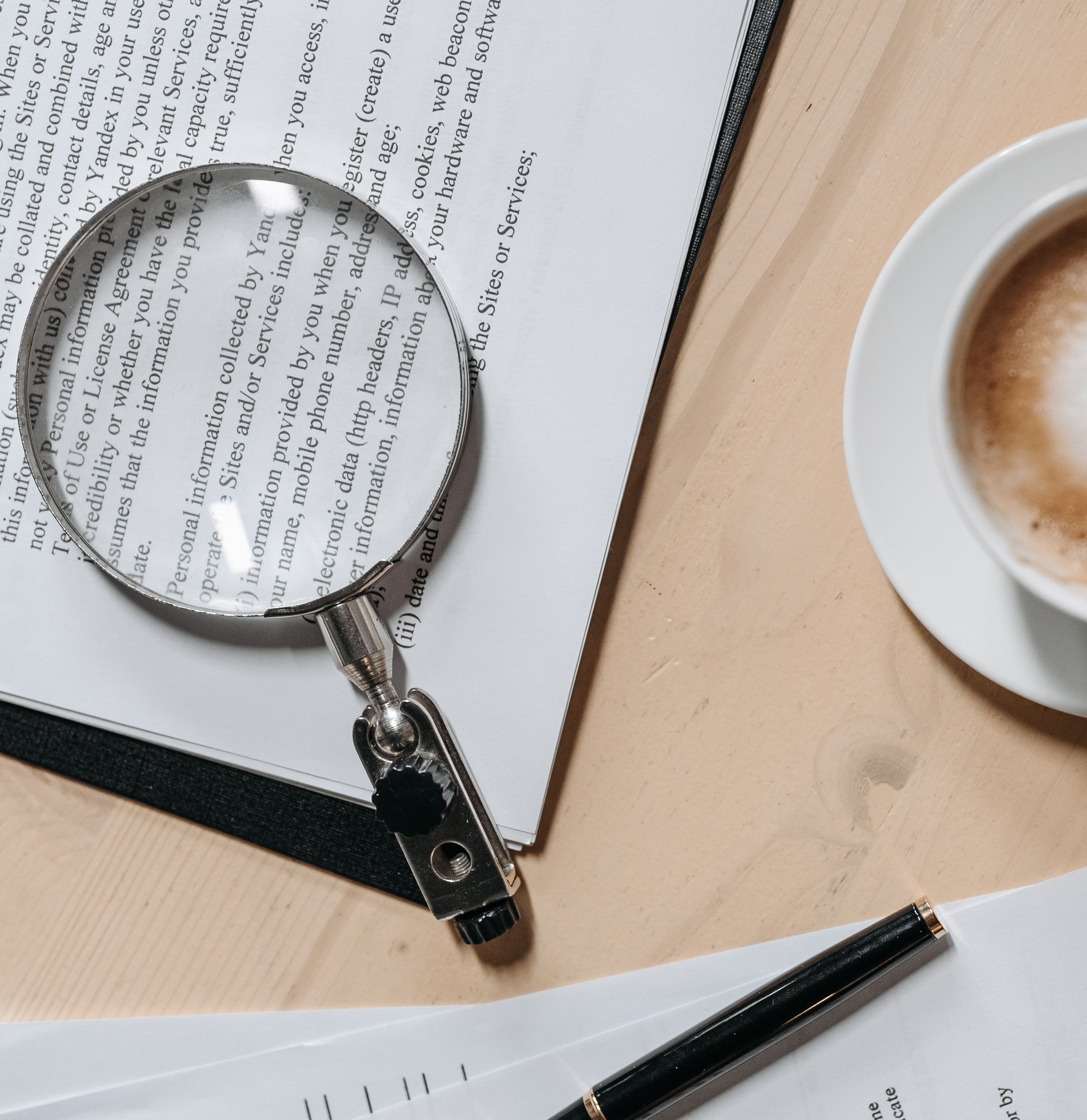A magnifying glass lying on top of a typed document.